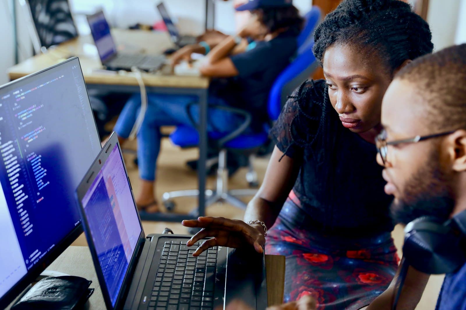 Software developers reviewing code together on laptops