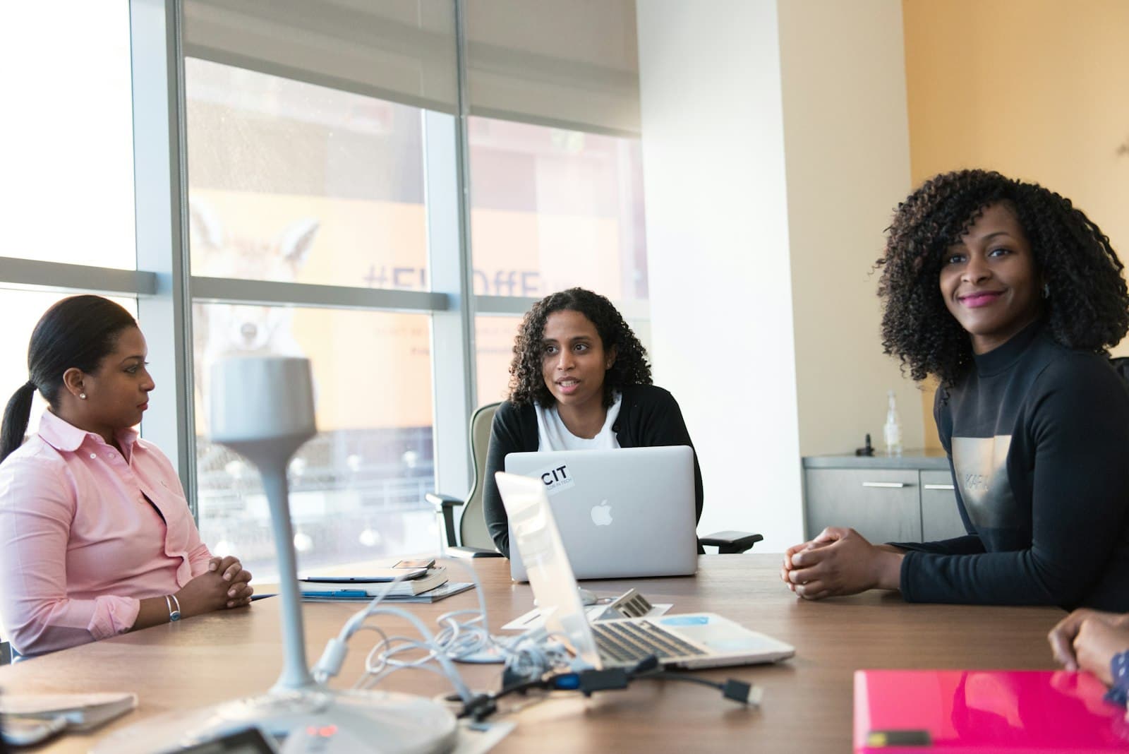 Three colleagues smiling during a meeting