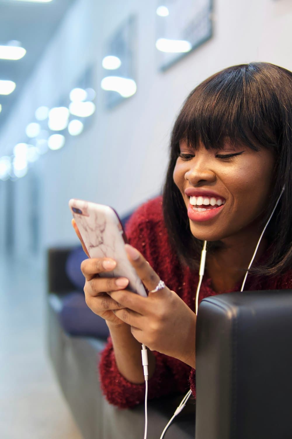 A woman smiling while using her smartphone